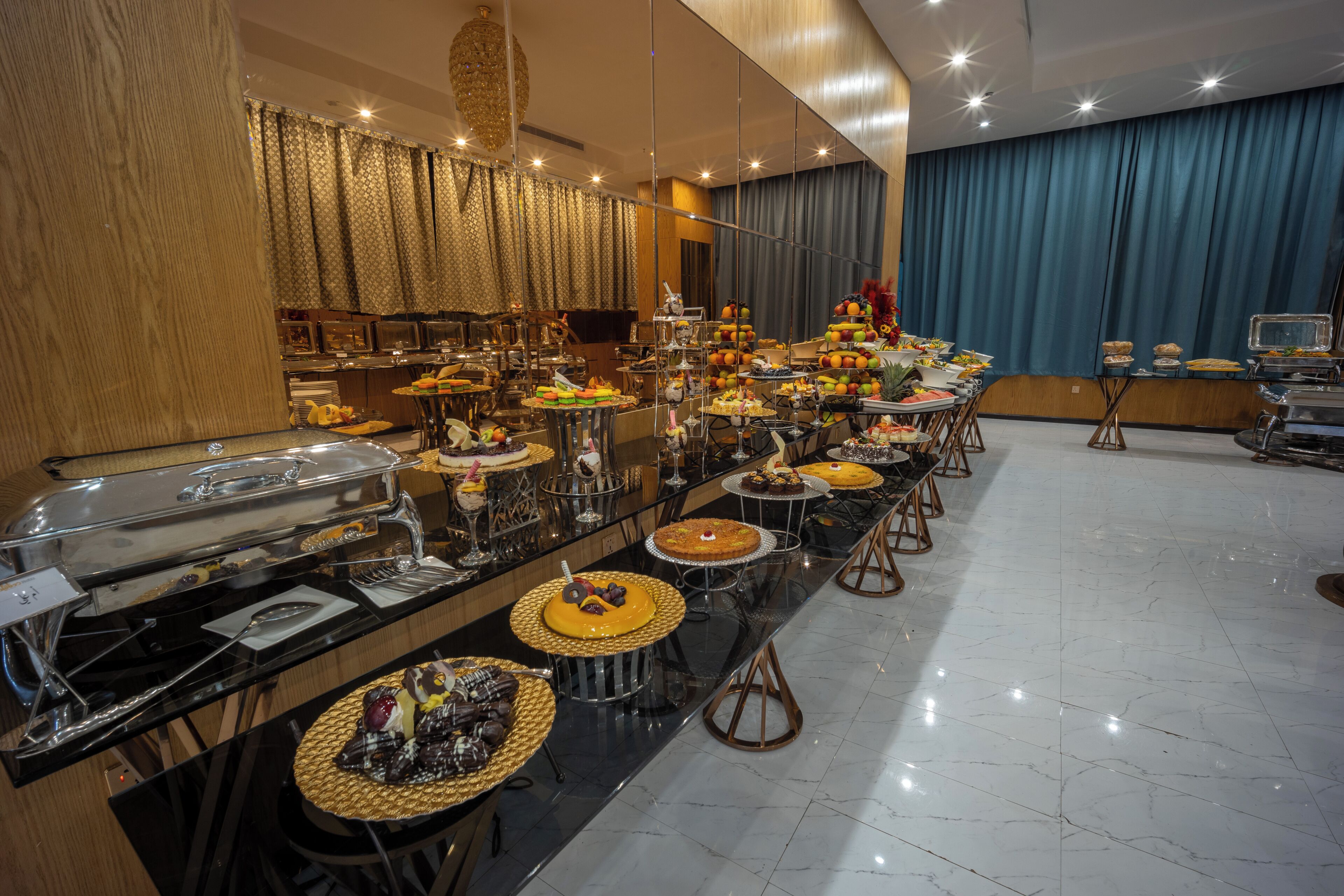 A buffet setup with various food stations, a bar area, and a seating arrangement.