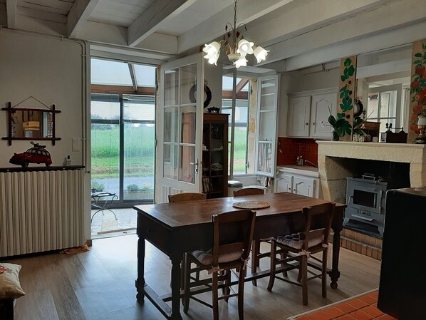 A kitchen with a wooden table and chairs, a built-in oven, and a large window.