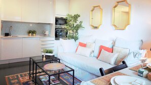 Un salon moderne avec un canapé, une table basse et un coin repas comprenant des assiettes et des verres.