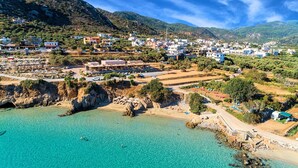 Une ville côtière aux eaux turquoise et limpides, bordée de falaises rocheuses et abritant un mélange de bâtiments résidentiels et commerciaux.