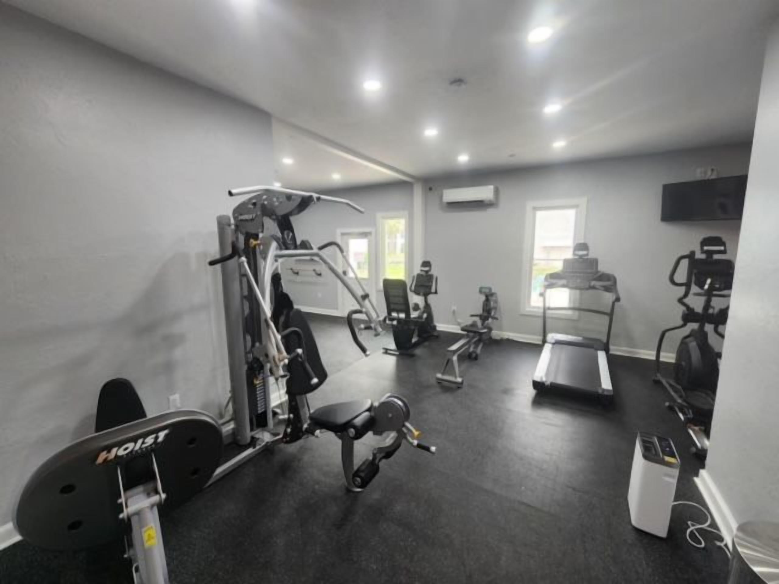 A gym with various exercise equipment including a treadmill, stationary bikes, and weight machines.