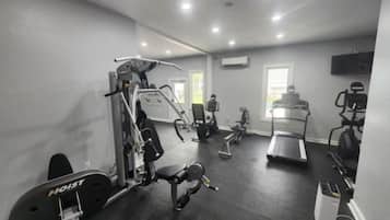 A gym with various exercise equipment including a treadmill, stationary bikes, and weight machines.