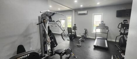 A gym with various exercise equipment including a treadmill, stationary bikes, and weight machines.