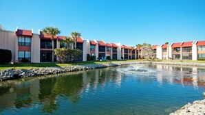 A hotel with multiple red-roofed buildings, a central water feature, and well-maintained landscaping. - Runaway Bay 213 - 1845191 (Bradenton Beach)