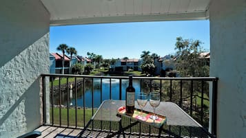 A balcony with a table, a bottle, and a glass.