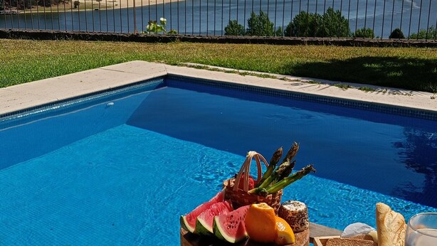 A poolside dining setup with a view of a lake and hills. - Holliday Villa - Casa do Sobreiro (Melres, Gondomar)