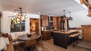 A modern kitchen with wooden cabinets, a central island, and pendant lighting. - Rocky Mountain Escape - Steps to Lake Estes, Jacuzzi, Close to Downtown Estes (Estes Park)
