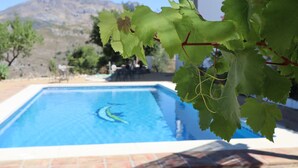 A swimming pool with a clear blue water surface, surrounded by a tiled deck. - Casa Arts (Alcaucin)