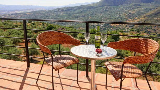 A terrace with wicker chairs and a table, overlooking a mountainous landscape. - Casa Arts (Alcaucin)