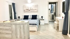 Una camera da letto con un letto, comodini, una scrivania e uno specchio.