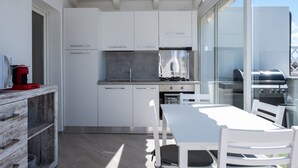 Una cucina moderna con mobili bianchi, piano cottura a gas e griglia integrata.