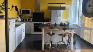Eine moderne Küche mit einer zentralen Kochinsel, weißen Schränken und einer gelben Akzentwand.
