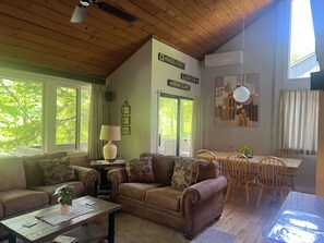 A cozy living room with a couch, coffee table, and dining table.