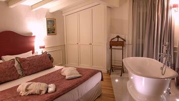 Une chambre avec un grand lit, une armoire en bois, une douche à l’italienne et un tableau accroché au mur.