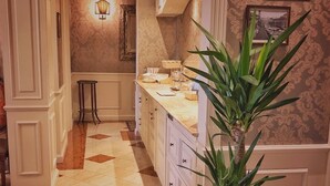 A kitchen with white cabinetry, a tiled floor, and a potted plant. - Relais Colle San Pietro (Verona)