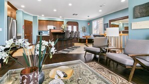 A spacious lobby with a reception desk, seating area, and a view of the kitchen in the background.