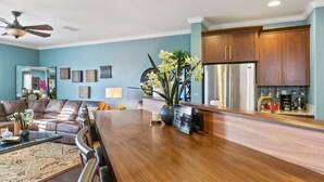 A modern kitchen with wooden cabinets, stainless steel appliances, and a wooden dining table.