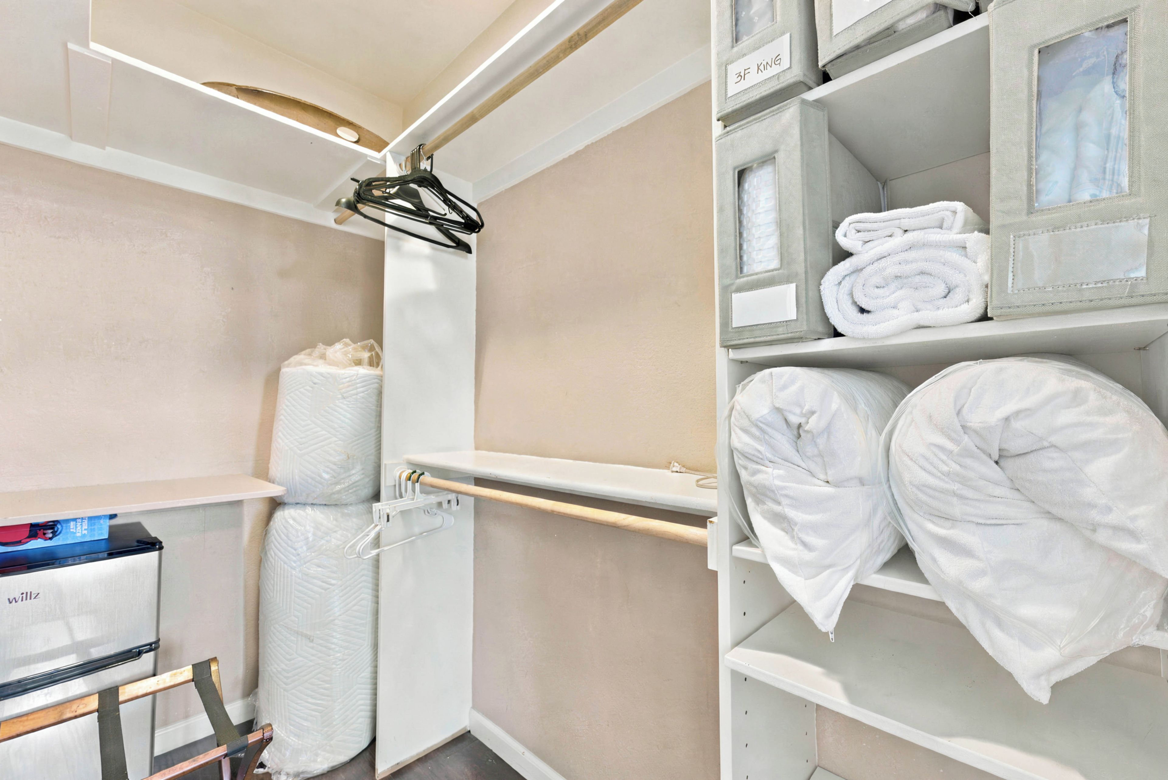 Ein Badezimmer mit Toilette, Waschbecken, Handtuchhalter und Ablage mit gefalteten Handtüchern.