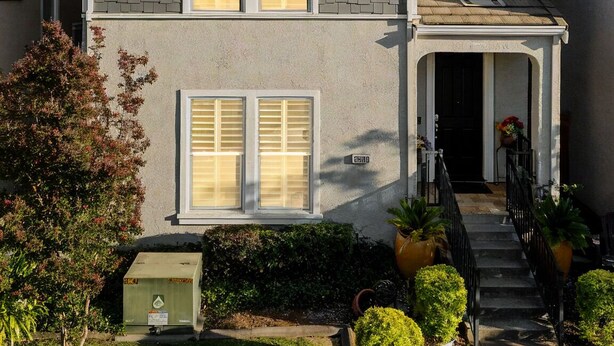 A two-story house with a front porch, a garage, and a well-maintained lawn.