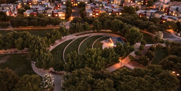 Ett bostadsområde med flera hus, en central, rund park och en liten byggnad med ett tak.