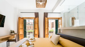 Una habitación de hotel moderna con una cama, un escritorio y un espejo grande.