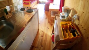 Een kleine keuken met houten wanden en een eethoek.