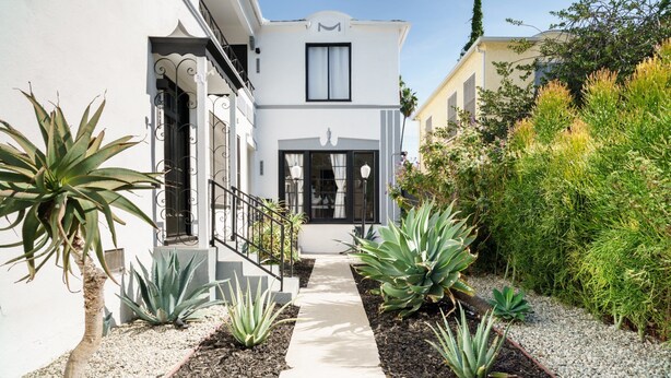 A modern house with a white facade, black-framed windows, and a central entrance. - Sun filled + Airy Large 2 Bedroom apt in West adam’s (Los Angeles)