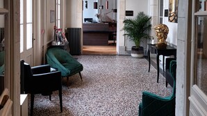 Een ruime lobby met hoge plafonds, grote ramen en een centraal gelegen receptiebalie.