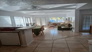Cozinha espaçosa com área de refeições, janelas amplas e ventilador de teto.