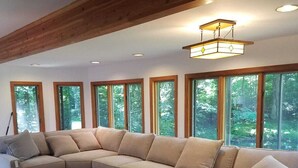 A large L-shaped sectional sofa in a room with wooden floors and large windows.