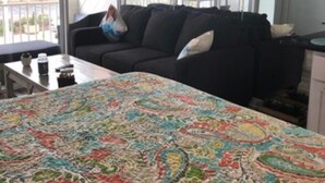 Et værelse med en stor seng, en mørk sofa, et lille bord og et vindue med udsigt.