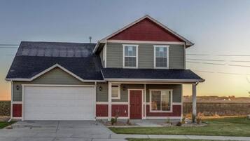 Stunning two-story home with a front porch and garage door.