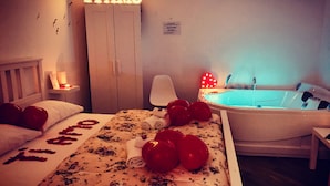 A bedroom with a bed, a nightstand, a wardrobe, a bathroom with a bathtub, and a sign that reads "TI AMO". - Sea Fly Guest House (Fiumicino)