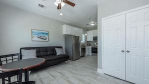 A modern kitchen with white cabinets, a stainless steel refrigerator, and a ceiling fan. - Charming cabin with full kitchen! Unit 3/6 (San Leon)