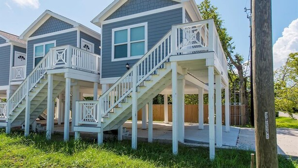 A row of two-story houses with attached porches and white railings. - Charming cabin with full kitchen! Unit 3/6 (San Leon)