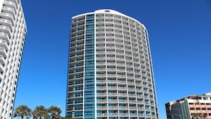 A tall, cylindrical hotel with multiple balconies and a modern design. - Oceans One by Palmetto Vacations (Myrtle Beach)