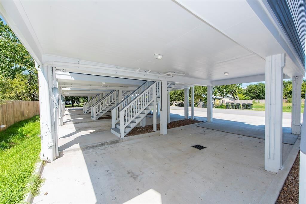 A covered outdoor area with a staircase leading to an upper level.