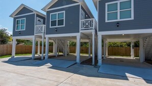 A row of two-story houses with attached garages, each featuring a covered patio area. - Charming cabin with full kitchen! Unit 5/6 (San Leon)