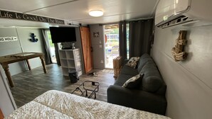 Un intérieur chaleureux avec un lit, un canapé, une table en bois et un téléviseur.