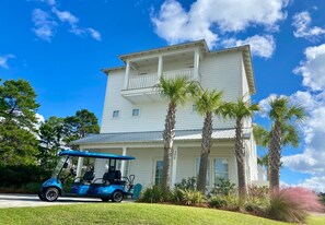 Guests can enjoy a balcony with a view of the beautifully landscaped grounds, featuring palm trees and a lawn.