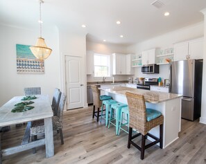 Enjoy meals in the kitchen and dining area with a central island and wooden table.