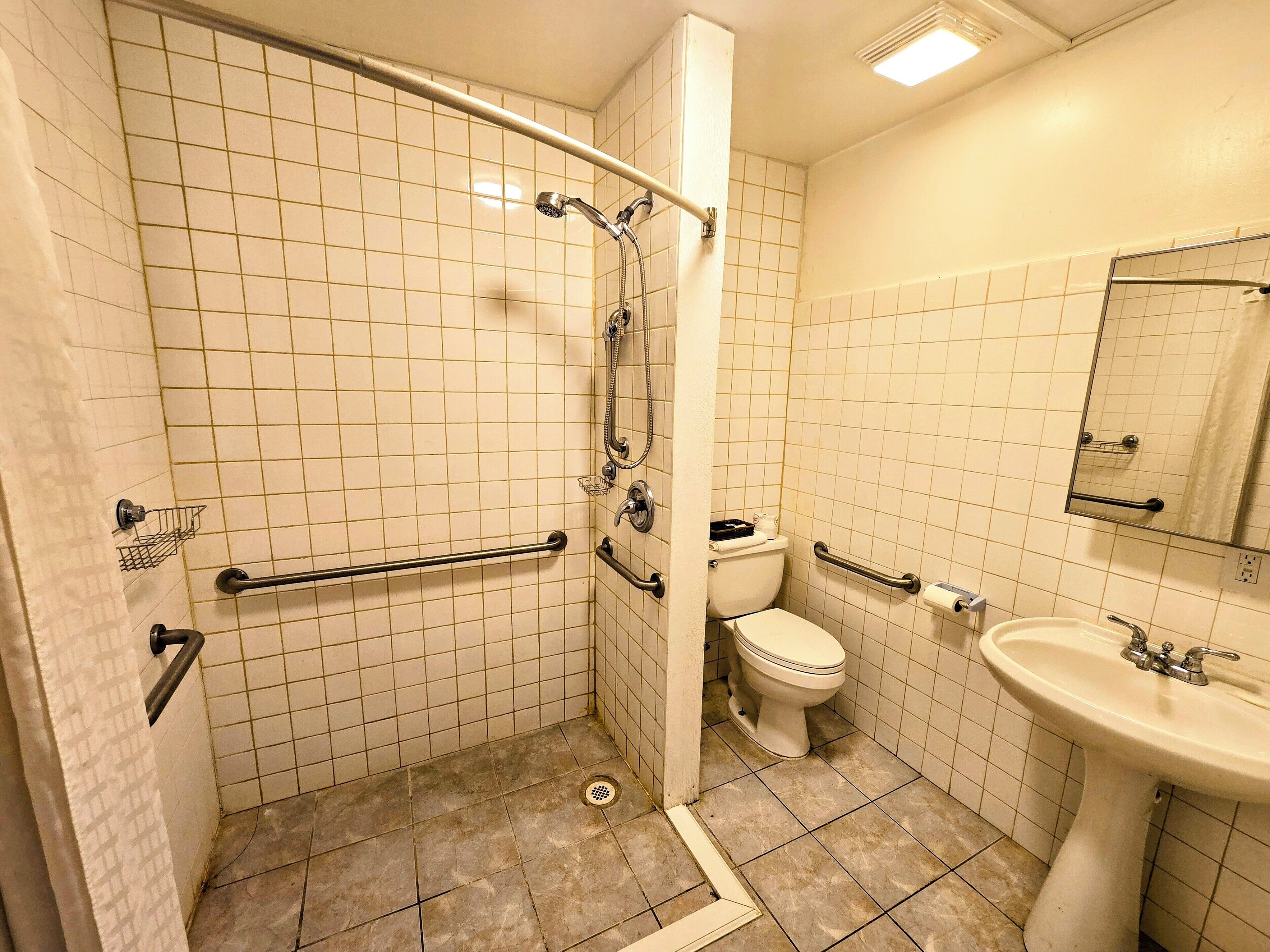 A bathroom with a shower, toilet, and sink.