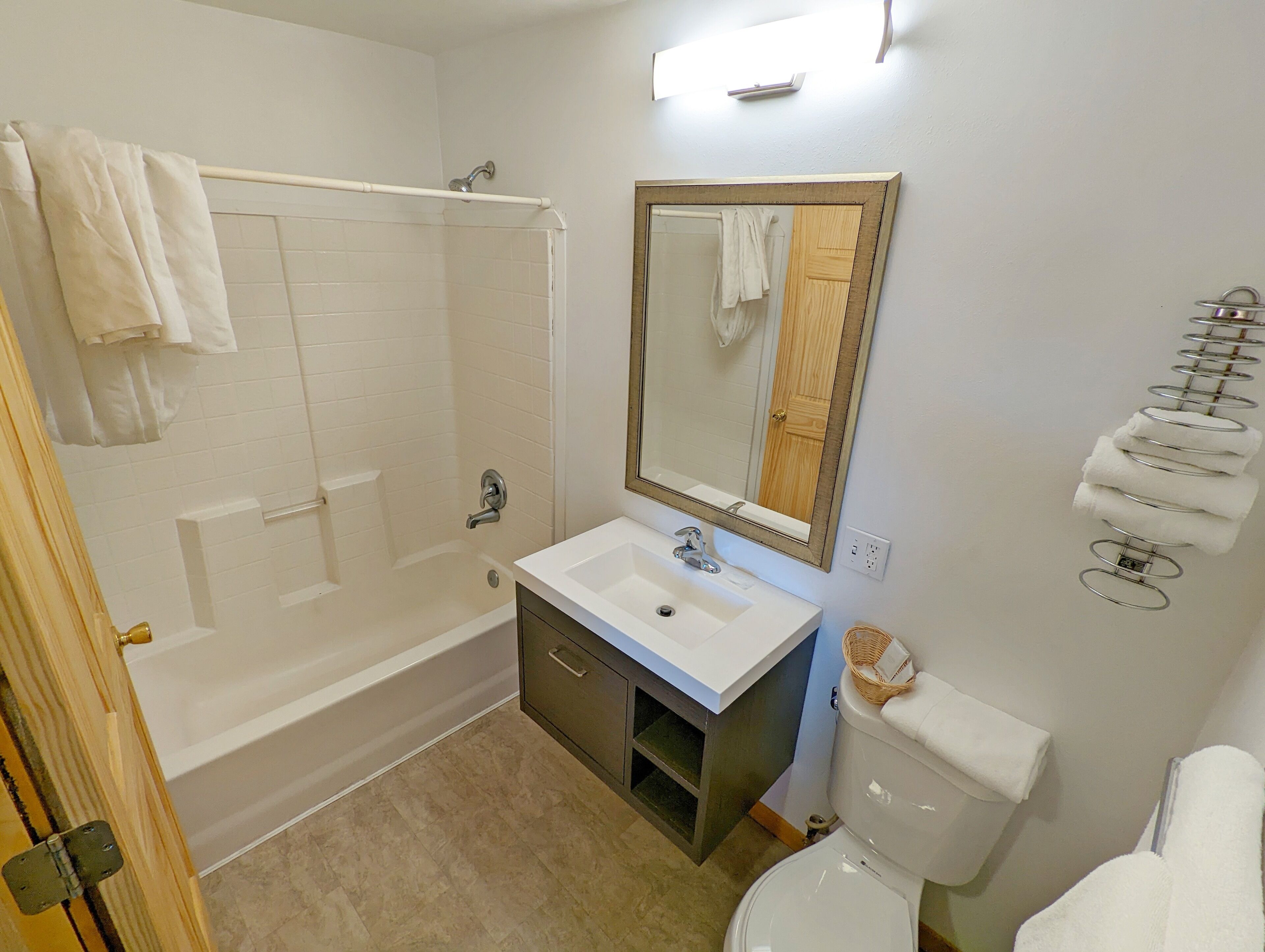 Un bagno con vasca, lavandino, specchio e water.