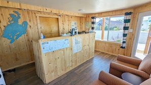 A wooden interior with a reception desk, a map, and a seating area. - Teton Court Motel (Pinedale)
