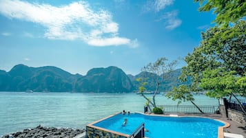 A swimming pool with a view of mountains and water.