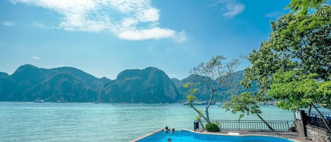 A swimming pool with a view of mountains and water.