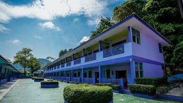 A two-story building with a flat roof, large windows, and a balcony on the upper floor.