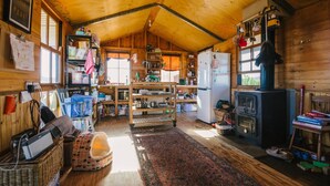 Una cucina accogliente in stile baita, con pareti e soffitto in legno, e un'isola centrale.