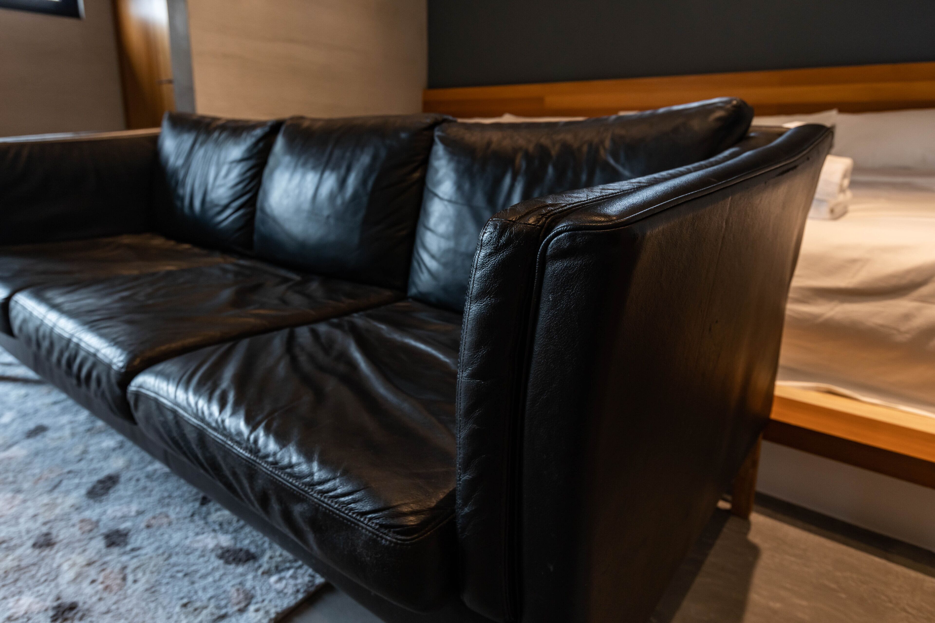 A black leather sofa in a hotel room.