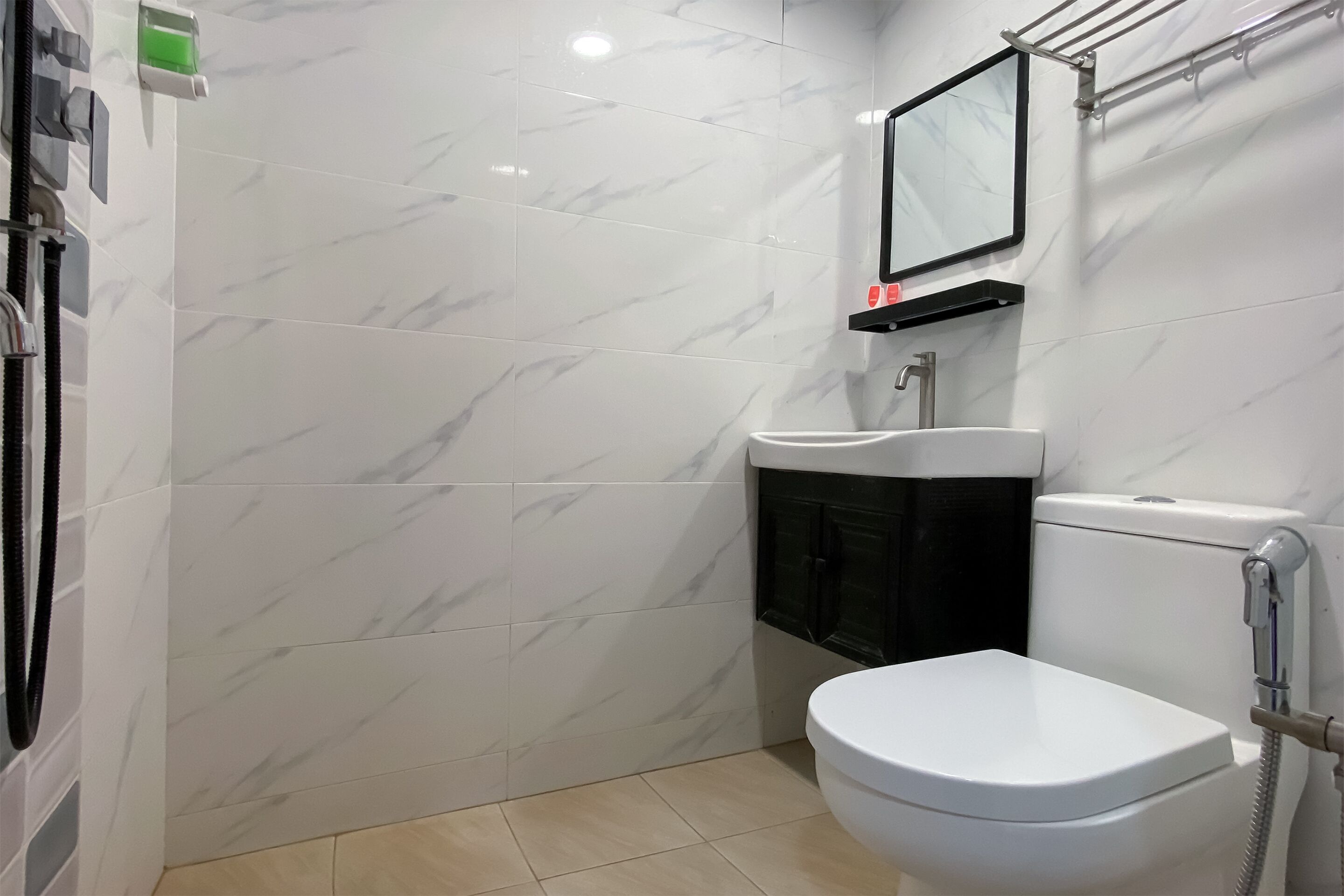 Een badkamer met toilet, wastafel en douche.